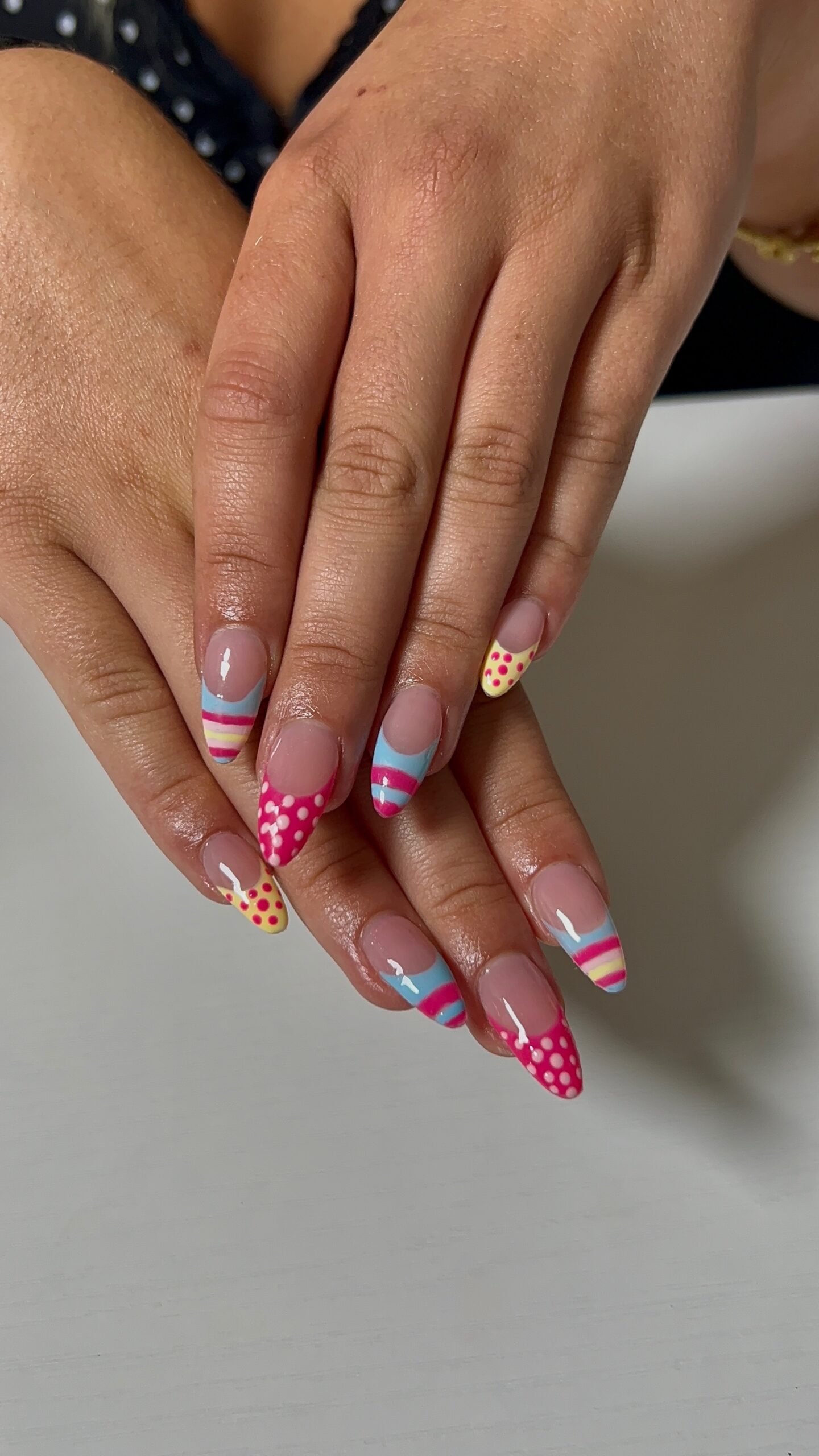 Colorful French tip and hand painted nail art on almond Gel-X nails at SR Studio