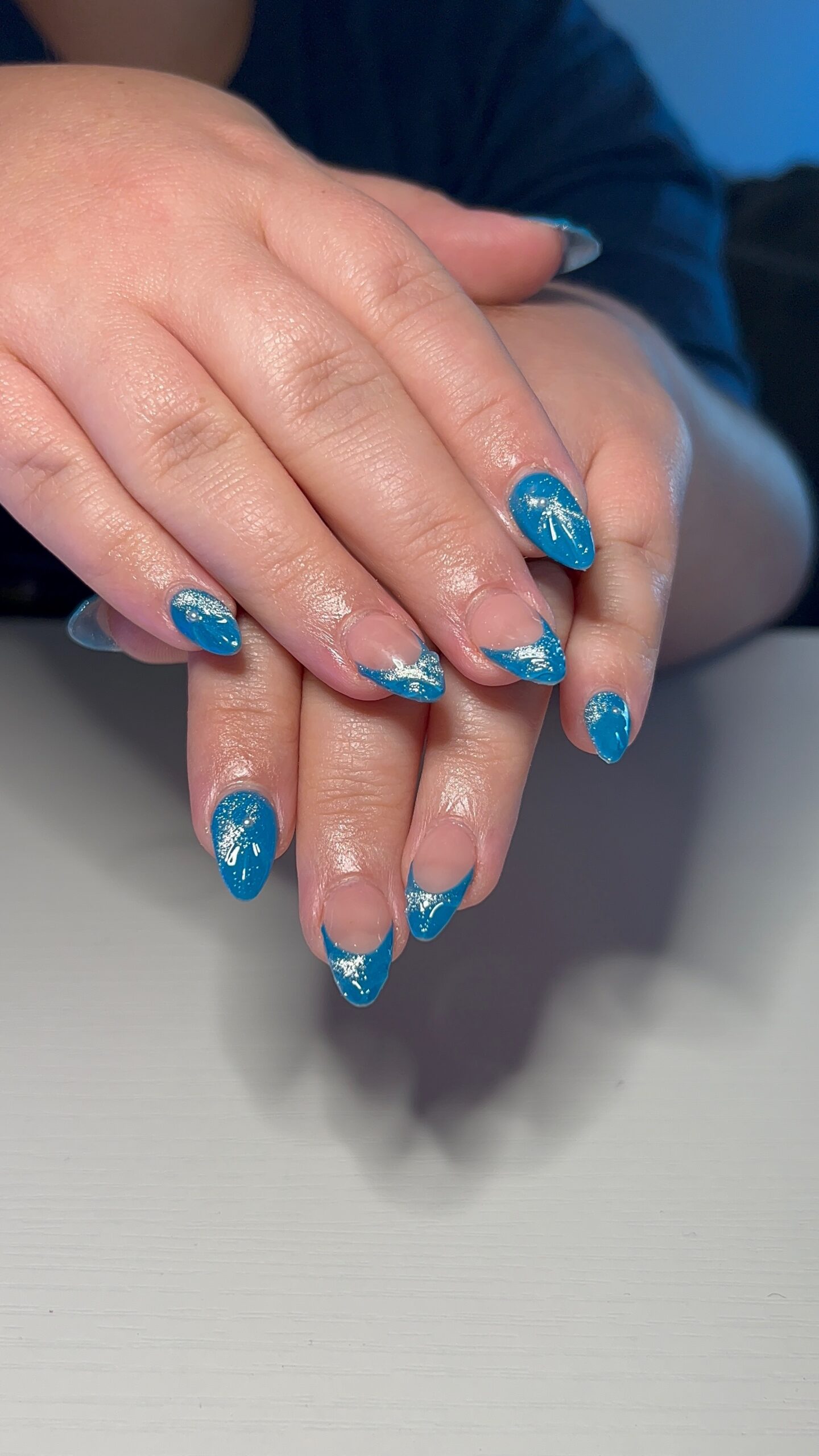 Blue French tip nail art on short almond Gel-X nails at SR Studio