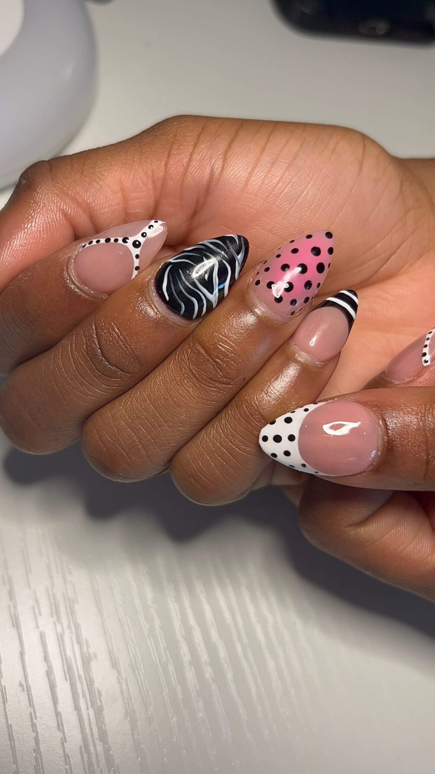 Short almond Gel-X nails with pink black and white graphic nail art